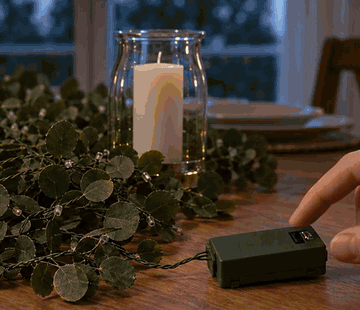 Ett finger trycker på strömbrytaren och GlowLine tänds på matbordet